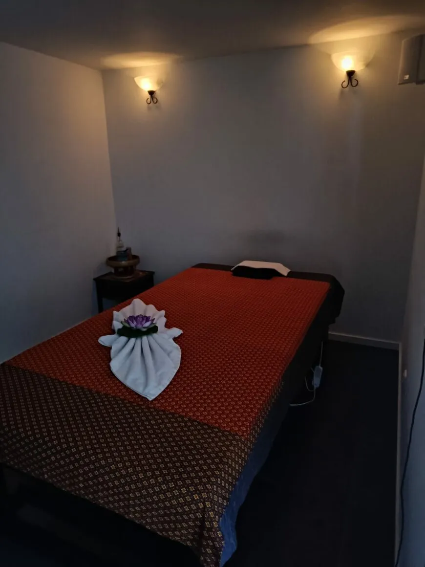 Tweede behandelkamer met een massagetafel en zacht wandlicht.
